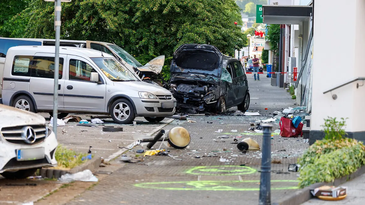 28.06.2023, Rheinland-Pfalz, Neuwied: Kaputte Autos stehen an der Unfallstelle, hinten rechts das Fahrzeug der Unfallverursacherin. In einer verkehrsberuhigten Zone hat es einen schweren Unfall gegeben. Dabei wurden nach ersten Informationen der Polizei vier Menschen schwer verletzt, zwei weitere erlitten leichte Verletzungen. Eine Frau war mit ihrem Fahrzeug nach jetzigem Stand der Ermittlungen von der Fahrbahn abgekommen und gegen Autos gefahren. Schließlich sei sie mit ihrem Auto in ein Schaufenster «gerutscht» und zum Stillstand gekommen, sagte ein Sprecher der Polizei. Die Frau wurde dabei schwer verletzt. Foto: Jörg Halisch/dpa - ACHTUNG: Autokennzeichen aus rechtlichen Gründen gepixelt +++ dpa-Bildfunk +++