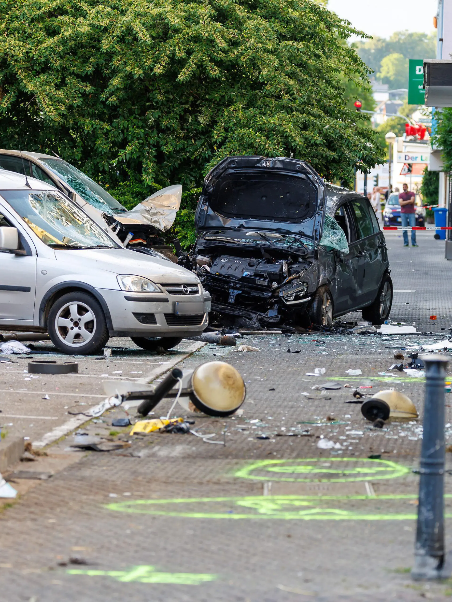28.06.2023, Rheinland-Pfalz, Neuwied: Kaputte Autos stehen an der Unfallstelle, hinten rechts das Fahrzeug der Unfallverursacherin. In einer verkehrsberuhigten Zone hat es einen schweren Unfall gegeben. Dabei wurden nach ersten Informationen der Polizei vier Menschen schwer verletzt, zwei weitere erlitten leichte Verletzungen. Eine Frau war mit ihrem Fahrzeug nach jetzigem Stand der Ermittlungen von der Fahrbahn abgekommen und gegen Autos gefahren. Schließlich sei sie mit ihrem Auto in ein Schaufenster «gerutscht» und zum Stillstand gekommen, sagte ein Sprecher der Polizei. Die Frau wurde dabei schwer verletzt. Foto: Jörg Halisch/dpa - ACHTUNG: Autokennzeichen aus rechtlichen Gründen gepixelt +++ dpa-Bildfunk +++