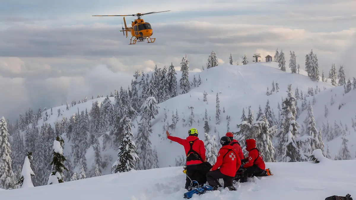 North Vancouver, British Columbia, Canada - Feb 17, 2020: North Shore Search and Rescue are rescuing a man skier with a broken leg in the backcountry of Seymour Mountain with a helicopter in winter.