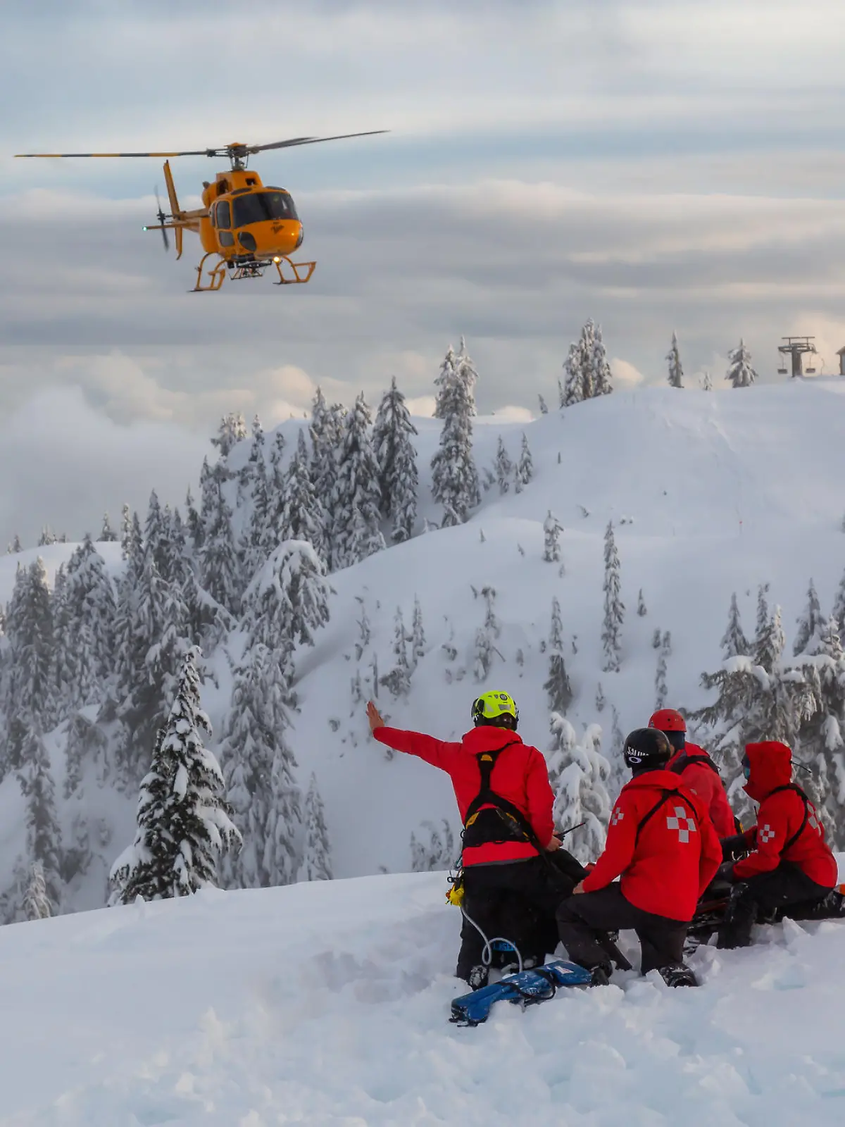 North Vancouver, British Columbia, Canada - Feb 17, 2020: North Shore Search and Rescue are rescuing a man skier with a broken leg in the backcountry of Seymour Mountain with a helicopter in winter.