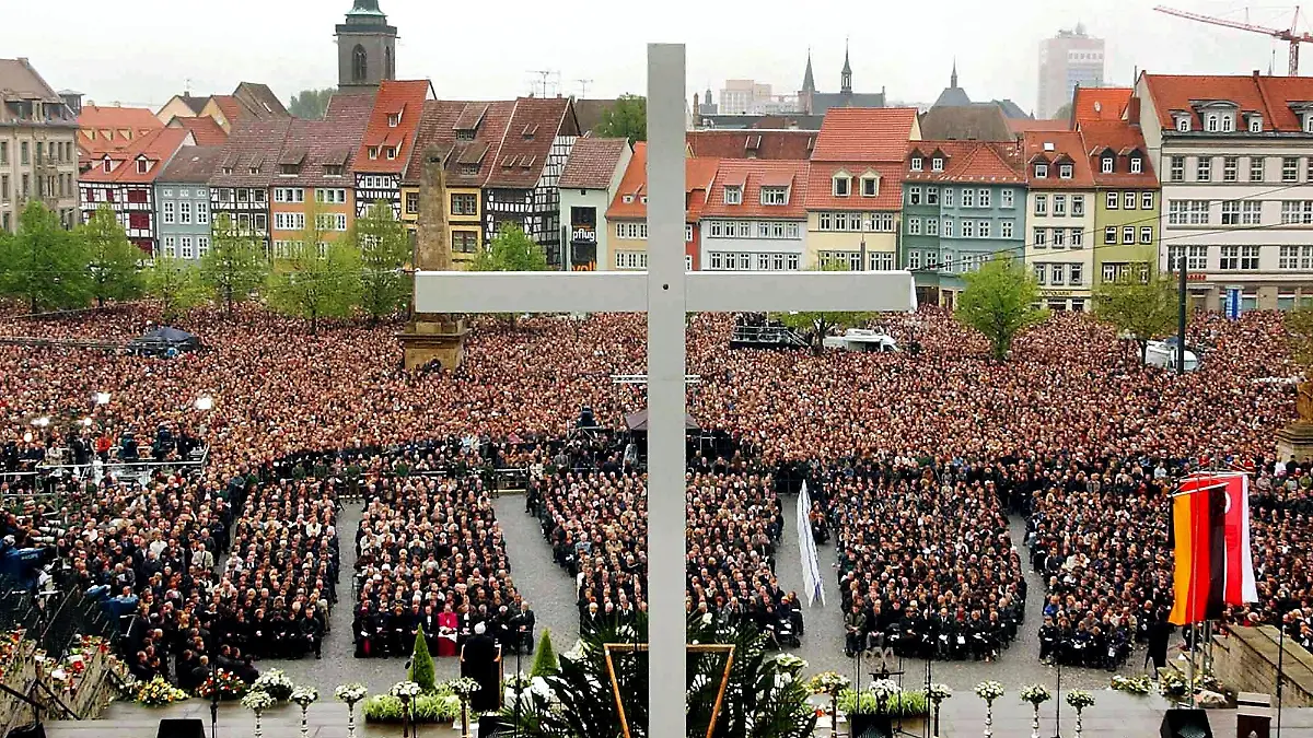 Tausende Trauernde nehmen an der zentralen Gedenkfeier für die Opfer des Amoklaufs im Gutenberg-Gymnasium am 3.5.2002 vor dem Erfurter Dom teil, vor dem ein großes Kreuz errichtet worden ist. Vor genau einer Woche hatte ein 19-jähriger ehemaliger Schüler an dem Gymnasium 16 Menschen und sich selbst getötet.