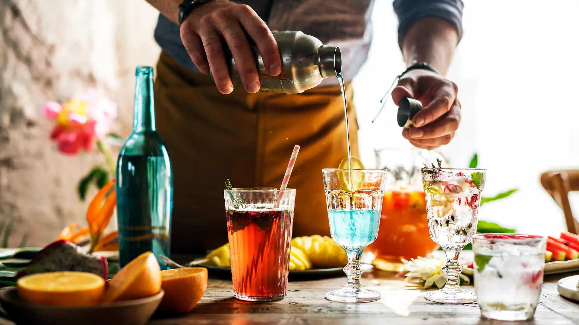 Ein Barkeeper, der Longdrinks mixt.