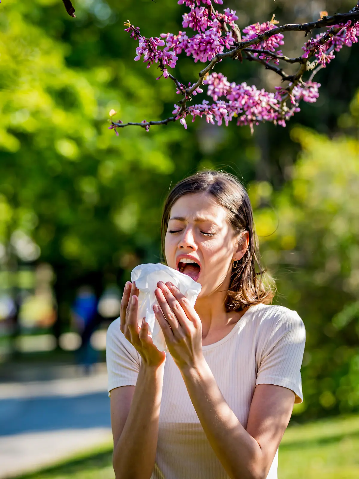 Woman has sneezing. Young woman is having flu and she is sneezing. Sickness, seasonal virus problem concept. Woman being sick having flu sneezing.
