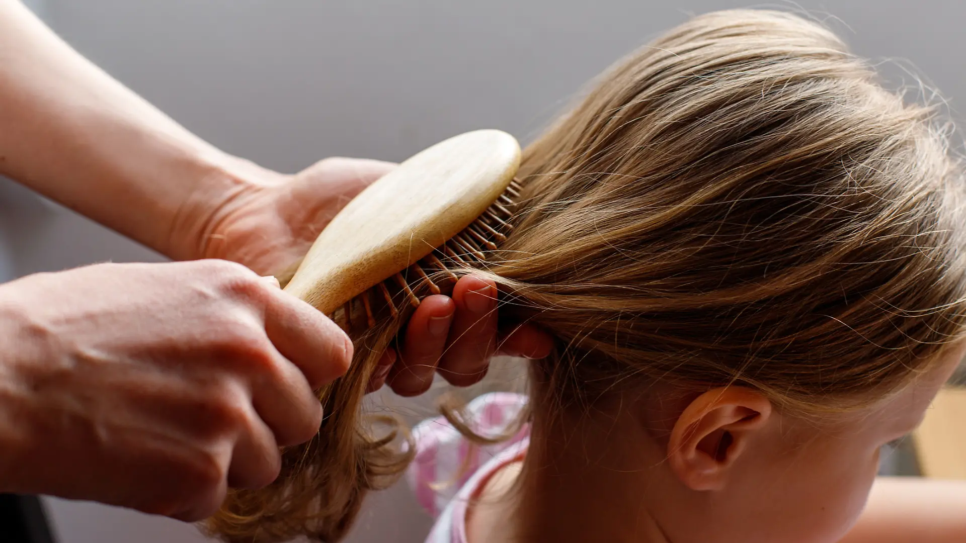 Mutter kämmt ihrer Tochter die Haare.