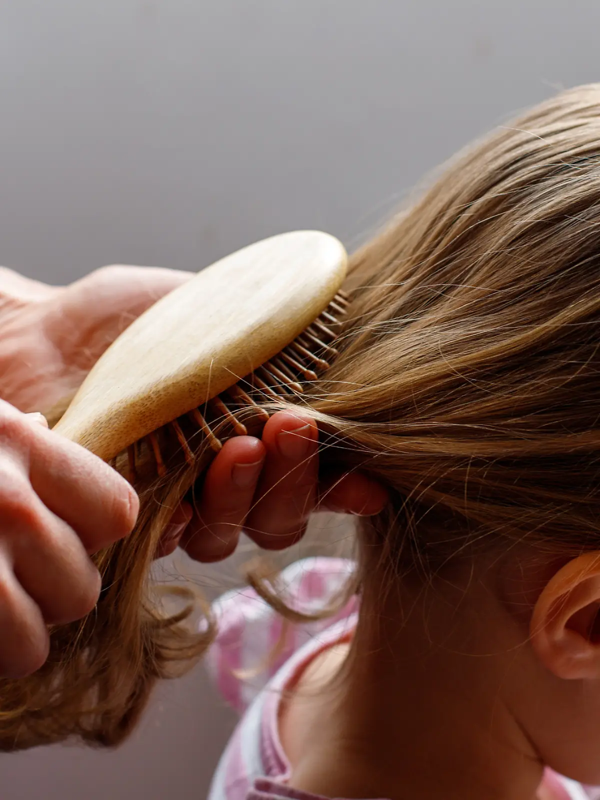 Mutter kämmt ihrer Tochter die Haare.