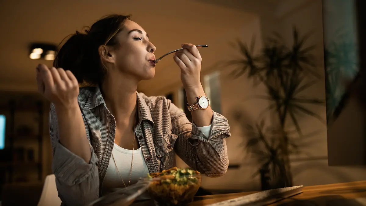 Frau isst Salat zum Abendessen.