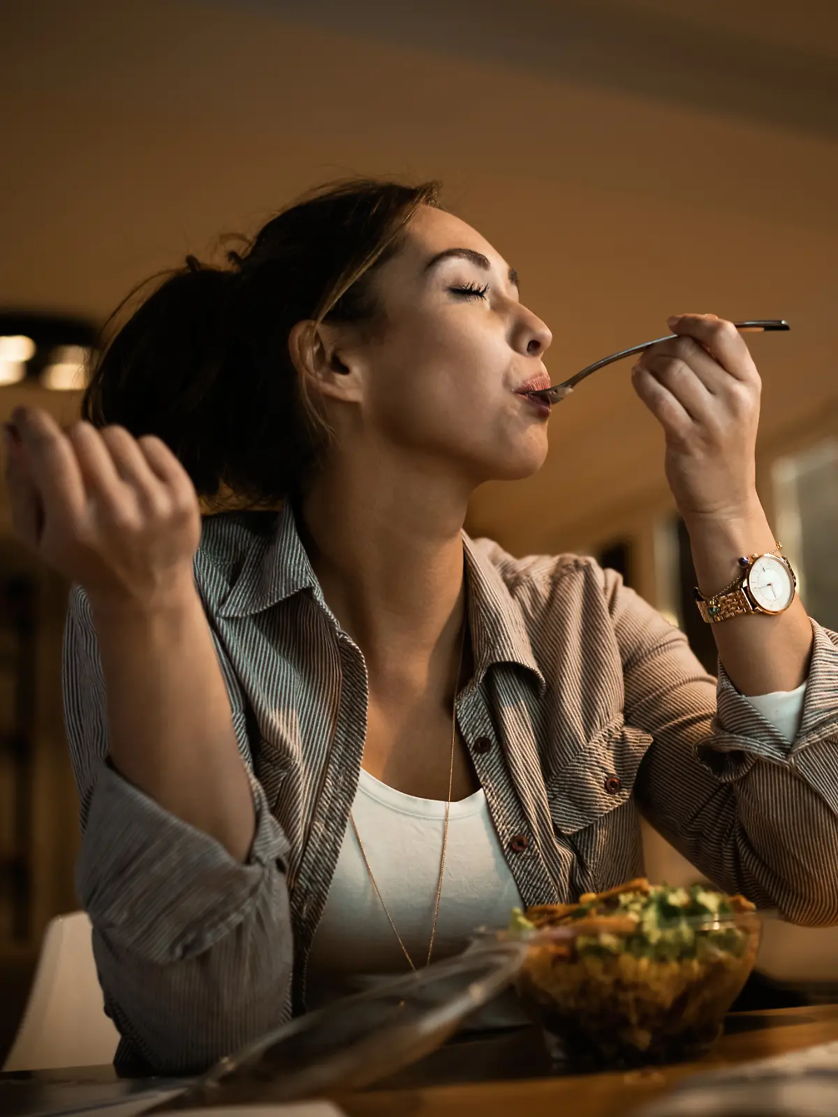 Frau isst Salat zum Abendessen.