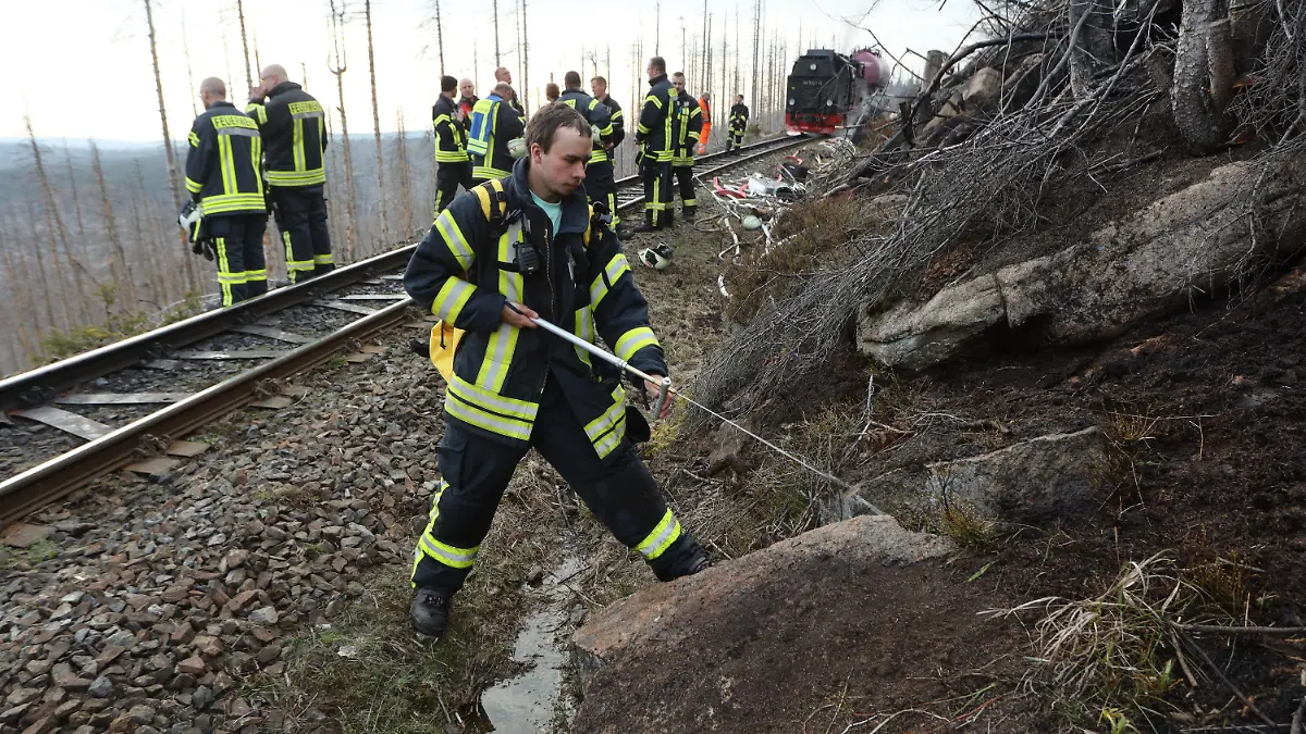 26.04.2022, Sachsen-Anhalt, Schierke: Einsatzkräfte der Feuerwehr stehen am Einsatzort auf dem Brocken. Auf der Ostseite des Harzes war ein Großfeuer ausgebrochen. Nach Angaben der Feuerwehr brannte es im Nationalpark zunächst auf einer Fläche von 3,5 Hektar. Das Gelände sei wegen der Hanglage für die Einsatzkräfte nur zu Fuß oder über die Brockenbahn erreichbar, sagte ein Feuerwehrsprecher aus Wernigerode. Foto: Matthias Bein/dpa +++ dpa-Bildfunk +++