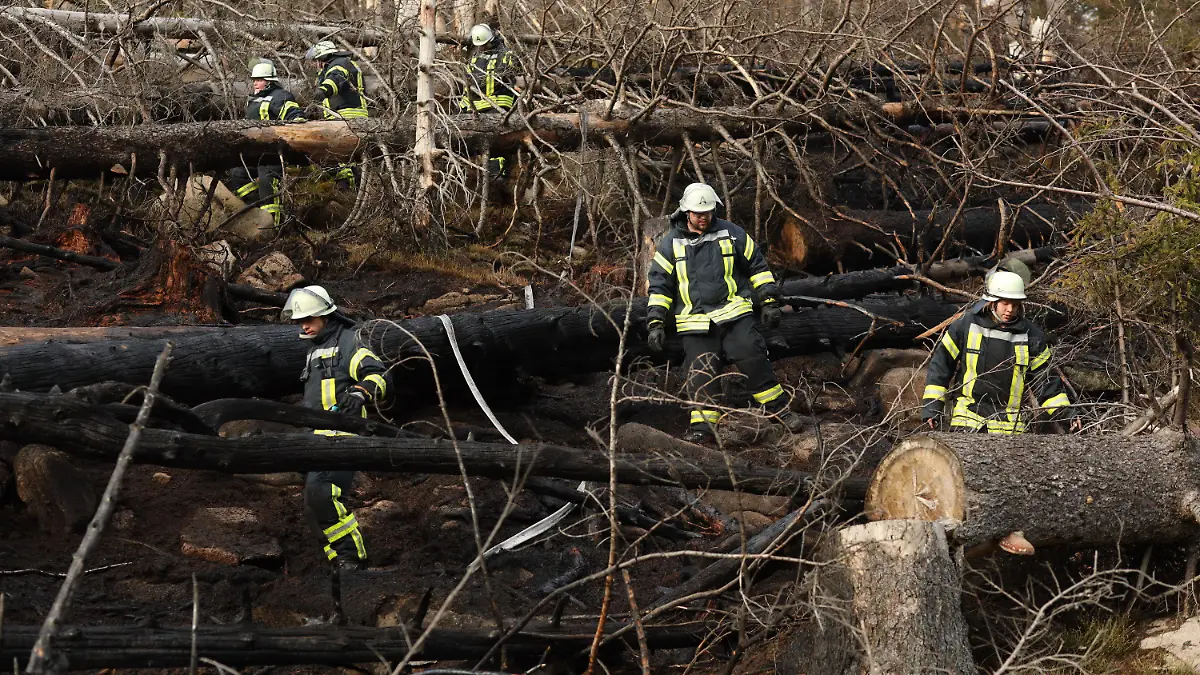 26.04.2022, Sachsen-Anhalt, Schierke: Einsatzkräfte der Feuerwehr kontrollieren eine abgebrannte Fläche am Brocken. Auf der Ostseite des Harzes war ein Großfeuer ausgebrochen. Nach Angaben der Feuerwehr brannte es im Nationalpark zunächst auf einer Fläche von 3,5 Hektar. Das Gelände sei wegen der Hanglage für die Einsatzkräfte nur zu Fuß oder über die Brockenbahn erreichbar, sagte ein Feuerwehrsprecher aus Wernigerode. Foto: Matthias Bein/dpa +++ dpa-Bildfunk +++