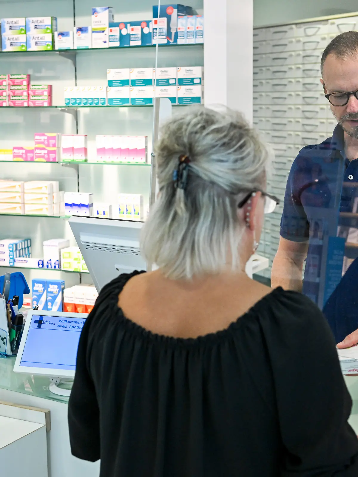 Eine Frau kauft in einer Apotheke ein.