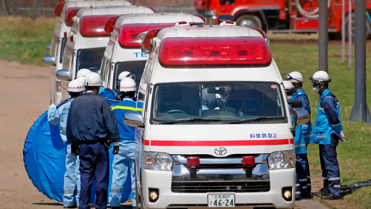 ADDS STORY UPDATE- Emergency personnel transfer a person retrieved from the tour boat accident, in Shari, in the northern island of Hokkaido Sunday, April 24, 2022. The tour boat with 26 aboard sank in rough waters Saturday. Ten people are confirmed to have died and the search continues for the other 16. (Koki Sengoku/Kyodo News via AP)