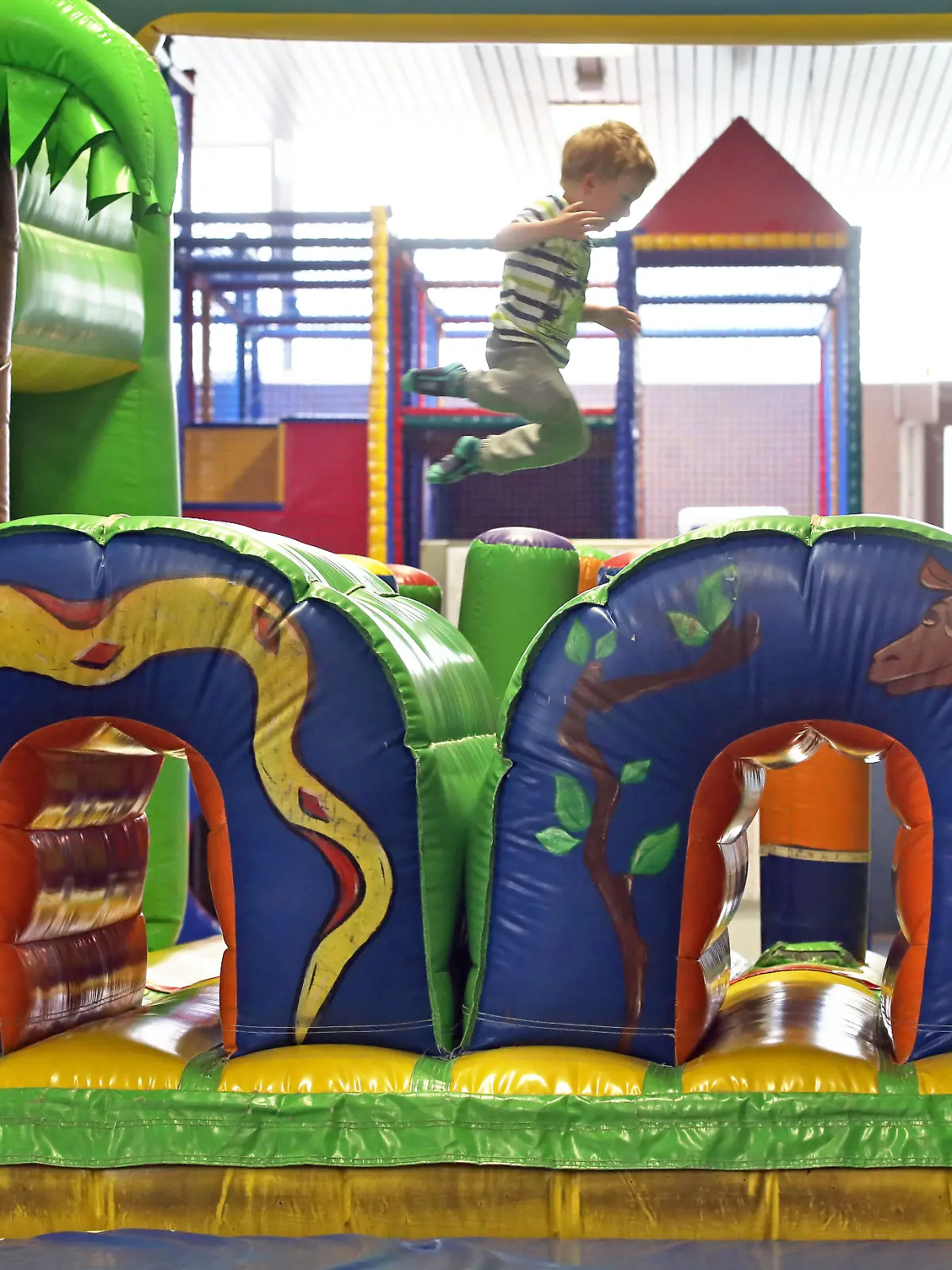 Ein kleiner Junge springt am 24.06.2014 in einer Hüpfburg im Kinderspielparadies Arche Noah in Halle/Saale (Sachsen-Anhalt). Die Indoorspielplätze im Land kämpfen gegen ihren schlechten Ruf an. 2006 schlug die Stiftung Warentest Alarm und kritisierte unsichere Spielgeräte sowie fehlende Kontrollen. Auf dem mit 5000 Quadratmetern nach Angaben der Betreiber größten Indoorspielplatz Ostdeutschlands wird auf gefährliche Angebote teils verzichtet.