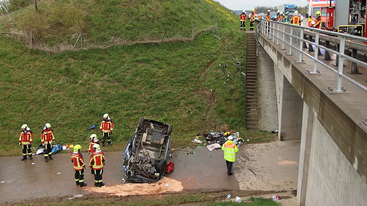 Feuerwehrleute und Polizei stehen an einer Unfallstelle an der Autobahn 8. Zwischen der Anschlussstelle Burgau und der Anschlussstelle Günzburg war eine 64-Jährige in ihrem Fahrzeug von der Fahrbahn abkommen. Sie fuhr ca. 200 Meter parallel zur Fahrbahn weiter, ehe das Auto an einer Brücke rund fünf Meter einen Abhang hinabstürzte. Auf einer Straße unter der Autobahn blieb das Fahrzeug auf dem Dach liegen. Alle vier Insassen wurden bei dem Unfall schwer verletzt.