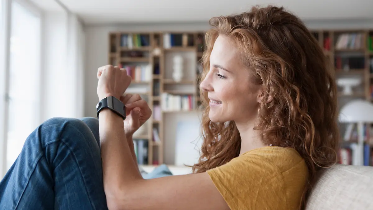 Frau guckt auf ihre Armbanduhr.