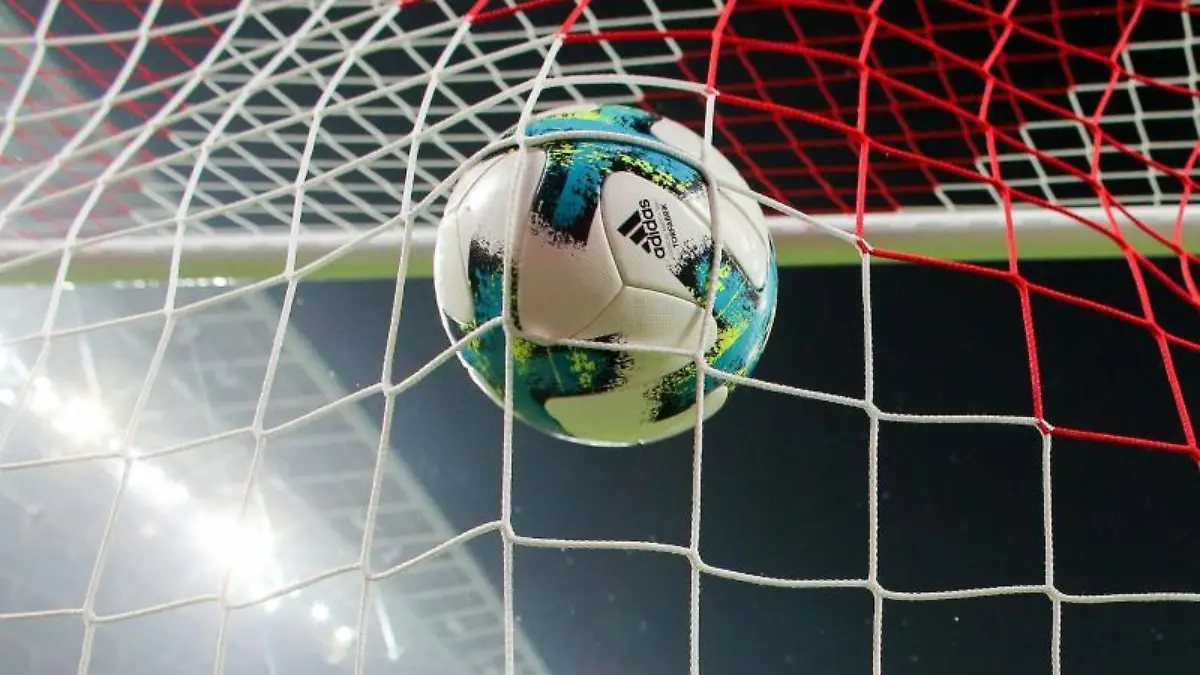 Ein Fußball fliegt ins Netz