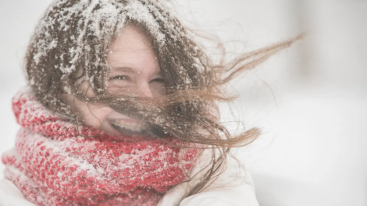 Teenager girl in the blue jacket and cape under snowfall at the street in Queens Village, New York City, NY, during the snowstorm Jonas