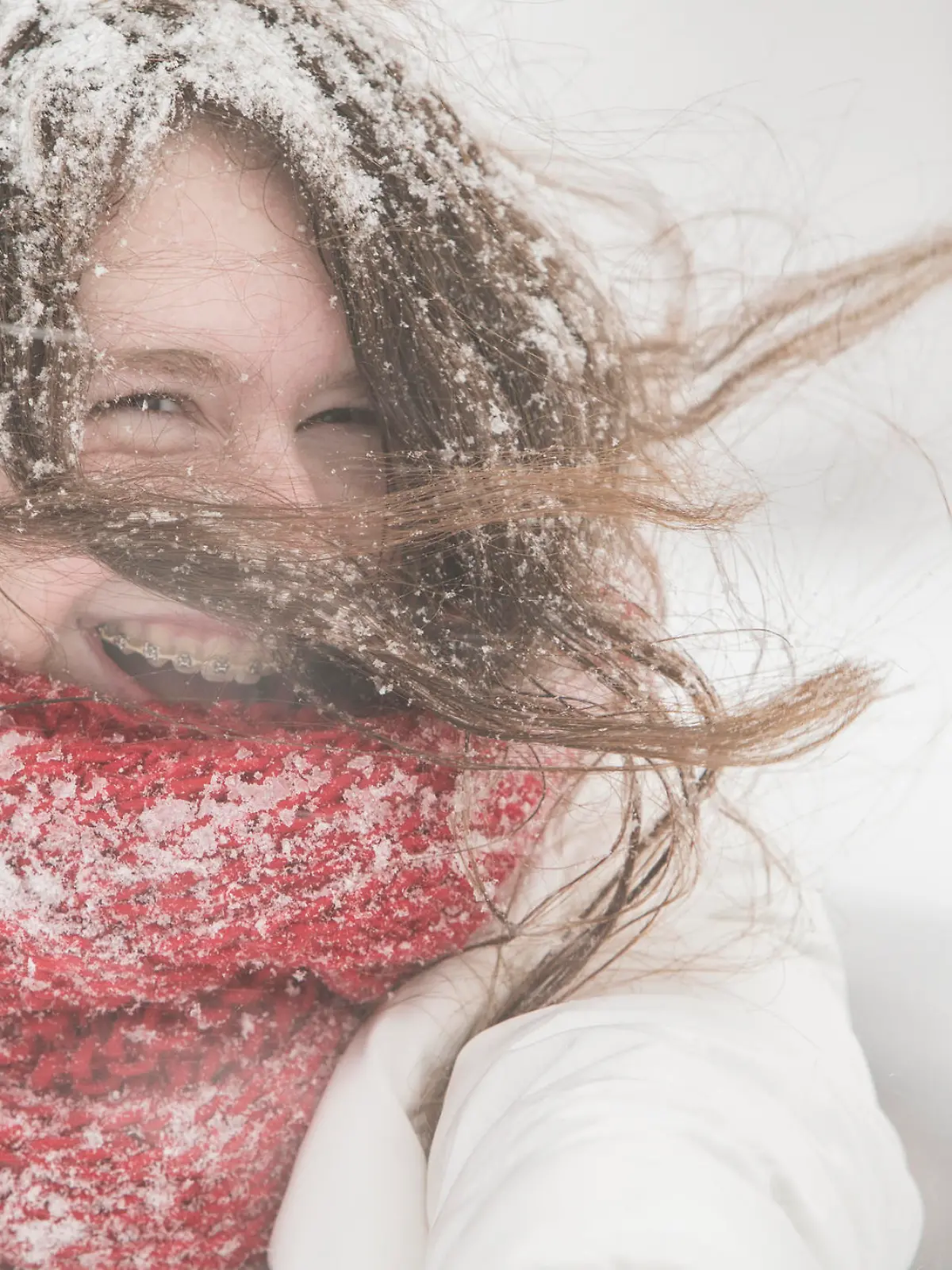 Teenager girl in the blue jacket and cape under snowfall at the street in Queens Village, New York City, NY, during the snowstorm Jonas