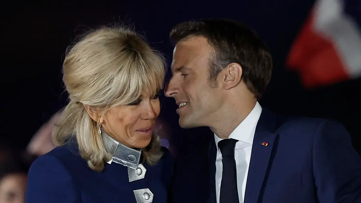 French President Emmanuel Macron kisses his wife Brigitte Macron after being re-elected as president, following the results in the second round of the 2022 French presidential election, during his victory rally at the Champs de Mars in Paris, France, April 24, 2022. REUTERS/Benoit Tessier