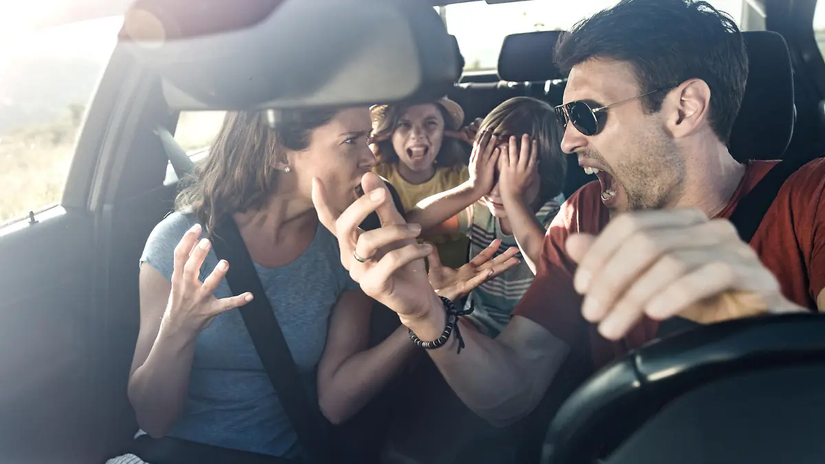 Angry parents arguing while traveling with their displeased kids in car. The view is through windshield.