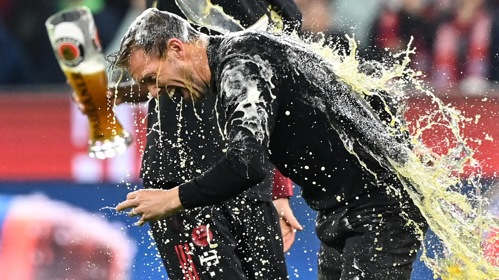 Fußball: Bundesliga, Bayern München - Borussia Dortmund, 31. Spieltag, Allianz Arena. Münchens Cheftrainer Julian Nagelsmann bekommt eine Bierdusche. (RECROP) WICHTIGER HINWEIS: Gemäß den Vorgaben der DFL Deutsche Fußball Liga bzw. des DFB Deutscher Fußball-Bund ist es untersagt, in dem Stadion und/oder vom Spiel angefertigte Fotoaufnahmen in Form von Sequenzbildern und/oder videoähnlichen Fotostrecken zu verwerten bzw. verwerten zu lassen.