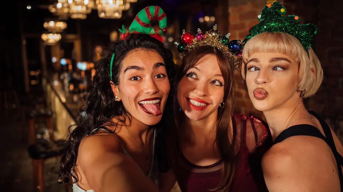 Drei junge Frauen haben Spaß an Weihnachten.
