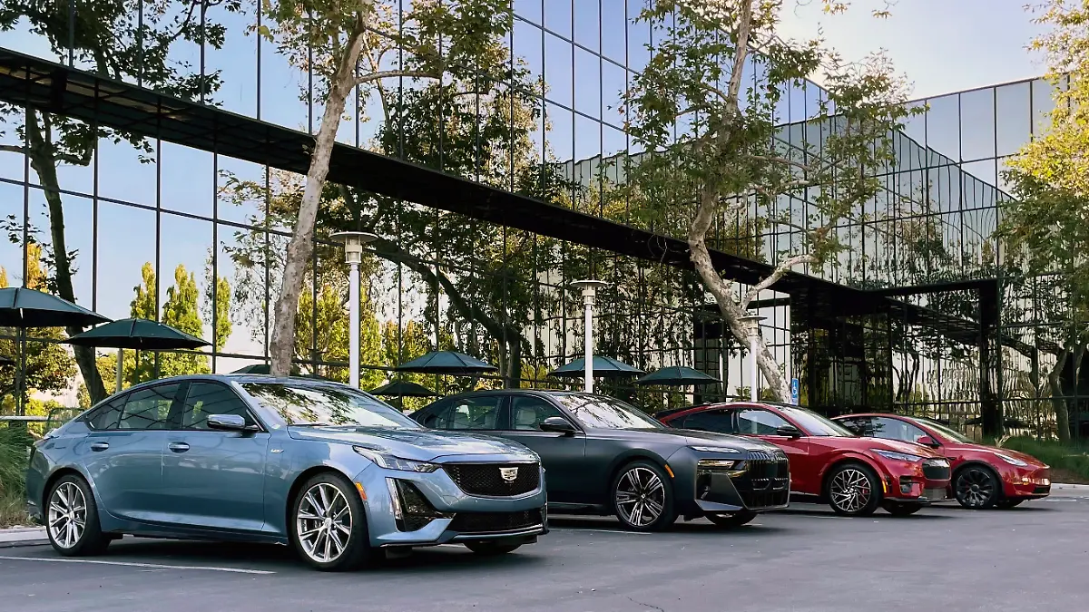 BMW, Cadillac und Tesla auf einem Parkplatz.