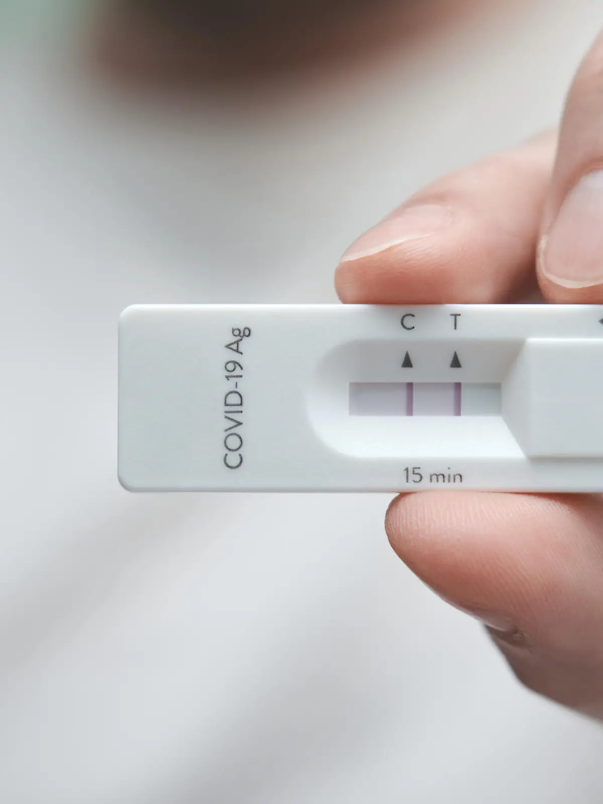 Close-up of a hand holding a positive antigen test for COVID-19. SARS-CoV-2 antigen rapid test kit.