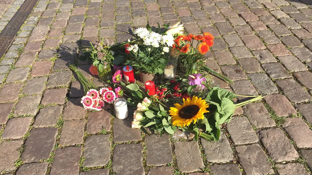 04.08.2020, Schleswig-Holstein, Kiel: Blumen liegen auf dem Platz vor dem Kieler Rathaus. Am 03.08.2020 ist eine 23-jährige Auszubildende vor dem Rathaus an ihrem ersten Ausbildungstag von einem agebrochenen Fahnenmast erschlagen worden. Die junge Frau wollte sich am Montagvormittag gemeinsam mit 50 weiteren neuen Azubis für ein gemeinsames Foto auf den Rathausplatz stellen. In diesem Moment sei am Rande des Platzes ein Lastwagen beim Rangieren gegen einen Fahnenmast gestoßen. Der Mast sei abgebrochen und auf die 23-Jährige gestürzt. Foto: Wolfgang Schmidt/dpa +++ dpa-Bildfunk +++