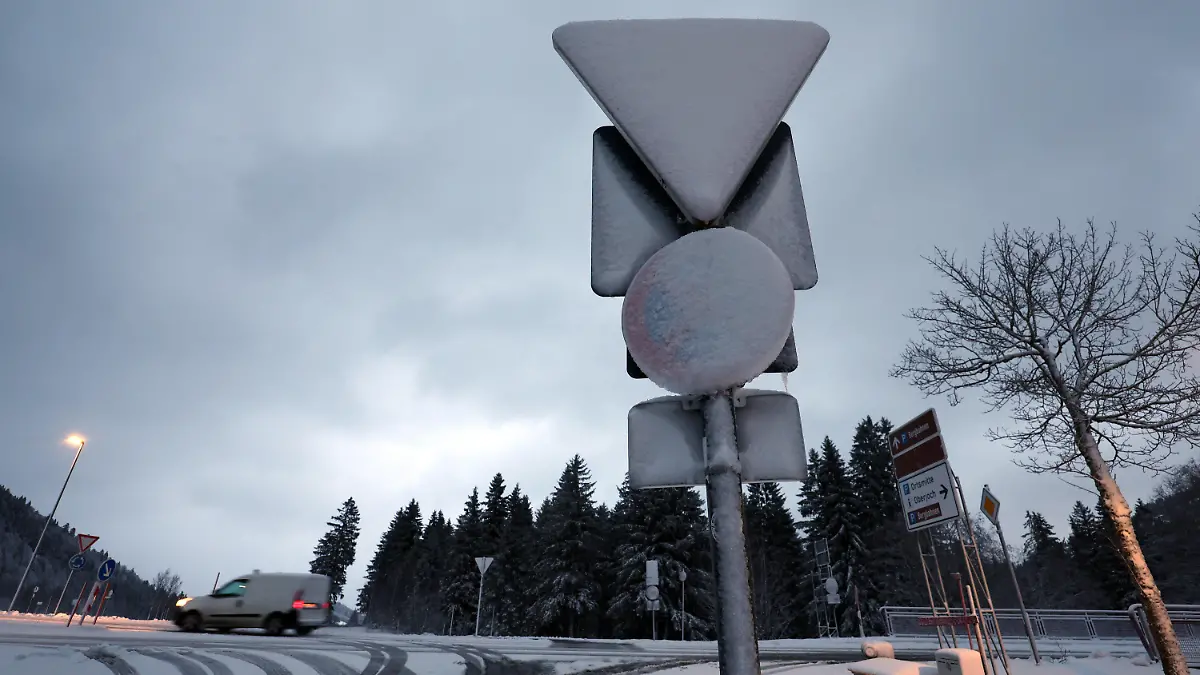 20.11.2024, Bayern, Bad Hindelang: Verkehrsschilder sind am frühen Morgen im Ortsteil Oberjoch mit Schnee bedeckt. Foto: Karl-Josef Hildenbrand/dpa +++ dpa-Bildfunk +++