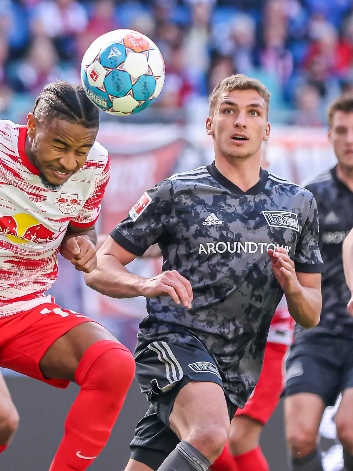 Fußball: Bundesliga, 31. Spieltag, RB Leipzig - 1. FC Union Berlin in der Red-Bull-Arena. Leipzigs Christopher Nkunku (l) gewinnt das Kopfballduell gegen Unions Grischa Prömel.