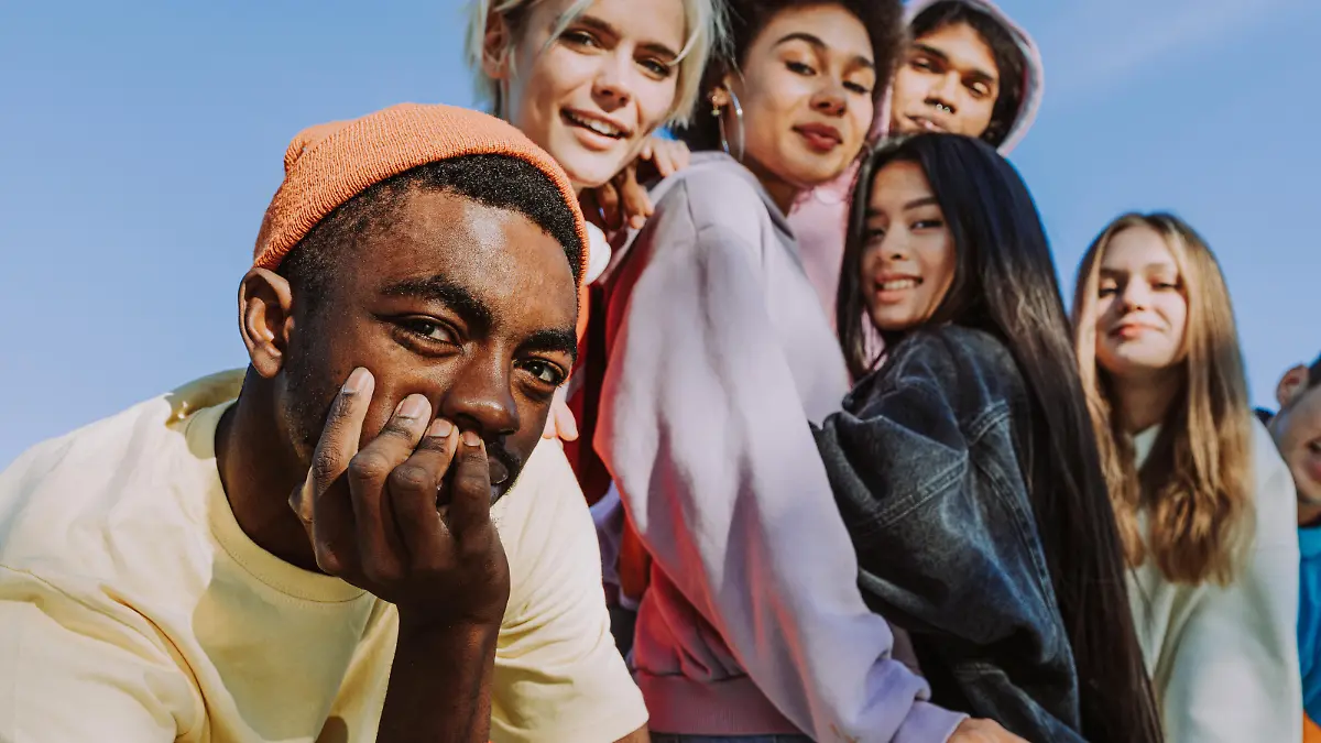 Multicultural group of young friends bonding outdoors and having fun - Stylish cool teens gathering at urban skate park