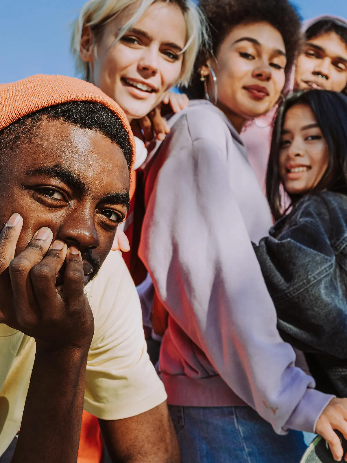 Multicultural group of young friends bonding outdoors and having fun - Stylish cool teens gathering at urban skate park