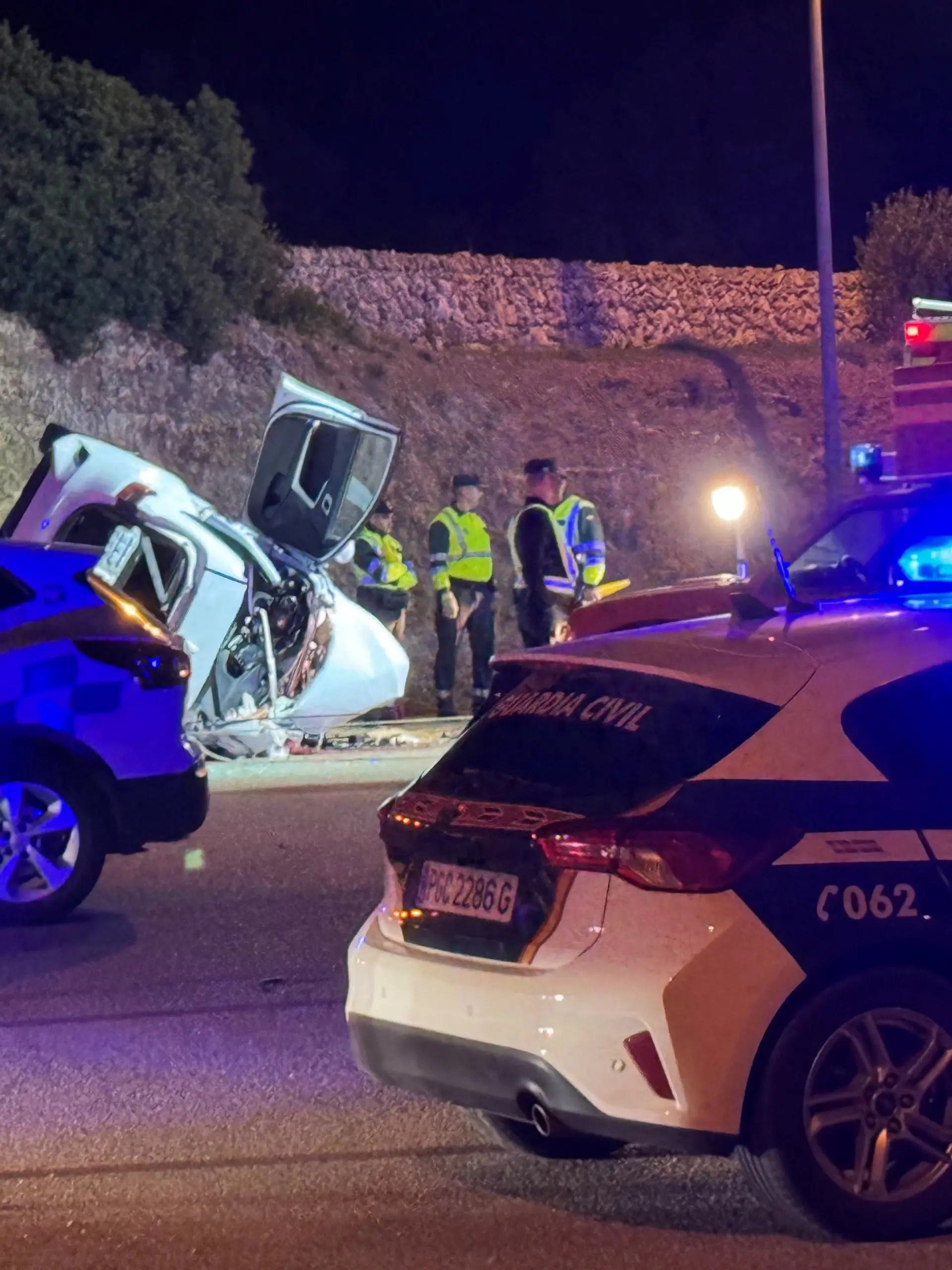 24.11.2024, Spanien, Mahón: Ein Auto liegt nach einem Unfall neben der Straße. Auf der spanischen Balearen-Insel Menorca sind Medienberichten zufolge sechs Menschen bei einem Autounfall ums Leben gekommen. Unter den Opfern seien zwei Erwachsene sowie vier Minderjährige im Alter zwischen 9 und 16 Jahren, schrieb das Online-Portal «Menorca al día» unter Berufung auf den Rettungsdienst. Foto: Tolo Mercadal/dpa +++ dpa-Bildfunk +++
