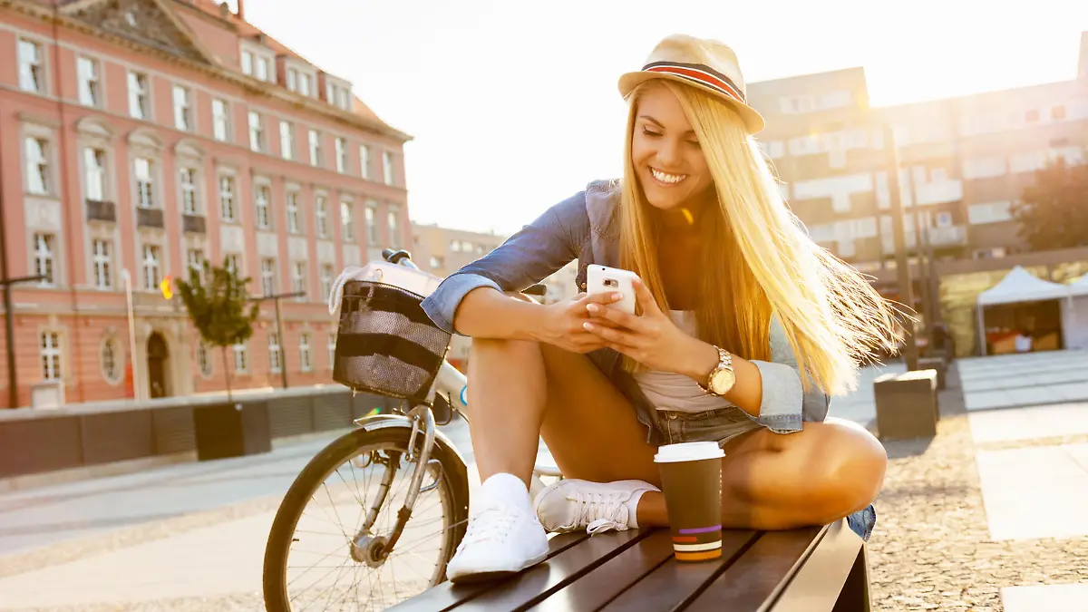 Young stylish woman with a bicycle in a city street