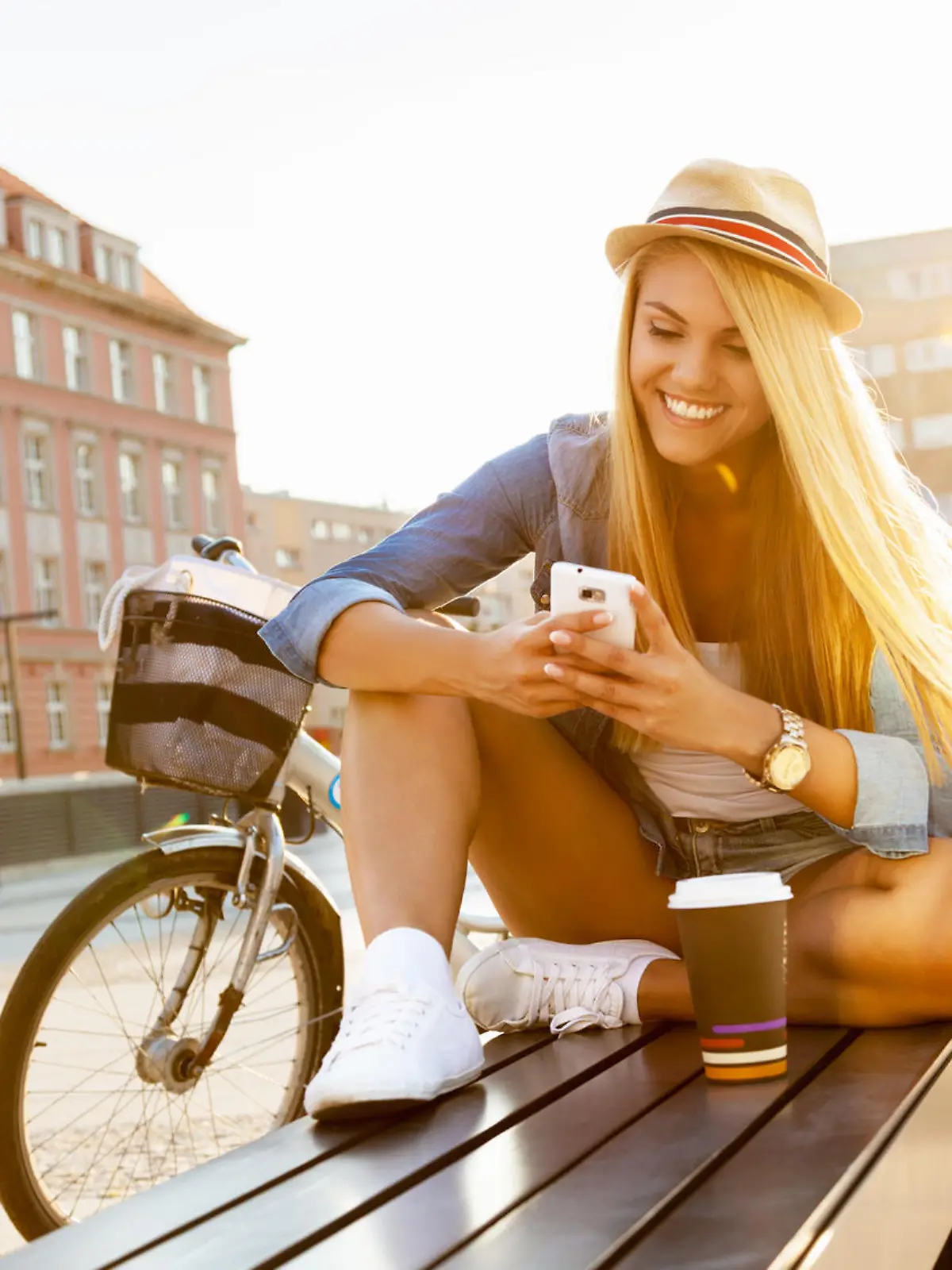 Young stylish woman with a bicycle in a city street