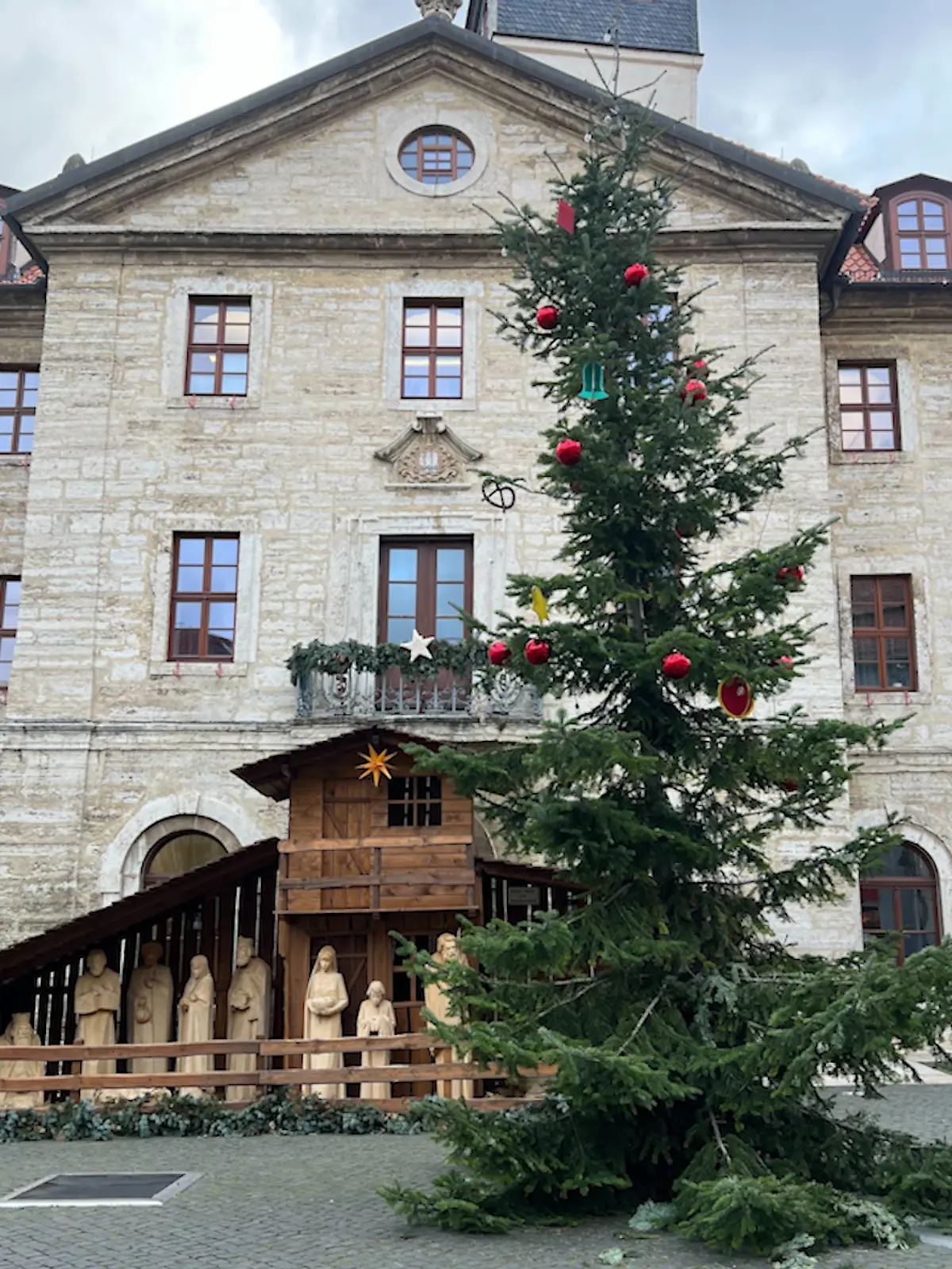 Ein schiefer Tannenbaum vor einem Rathaus.