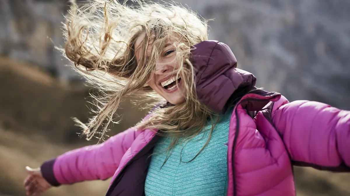  Happy young woman leaning against the wind in the mountains model released Symbolfoto PUBLICATIONxINxGERxSUIxAUTxHUNxONLY PNEF00480