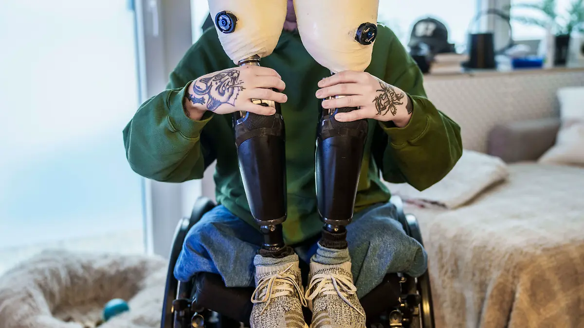 Alexander Sauer hält seine beiden Hightech-Prothesen hoch.