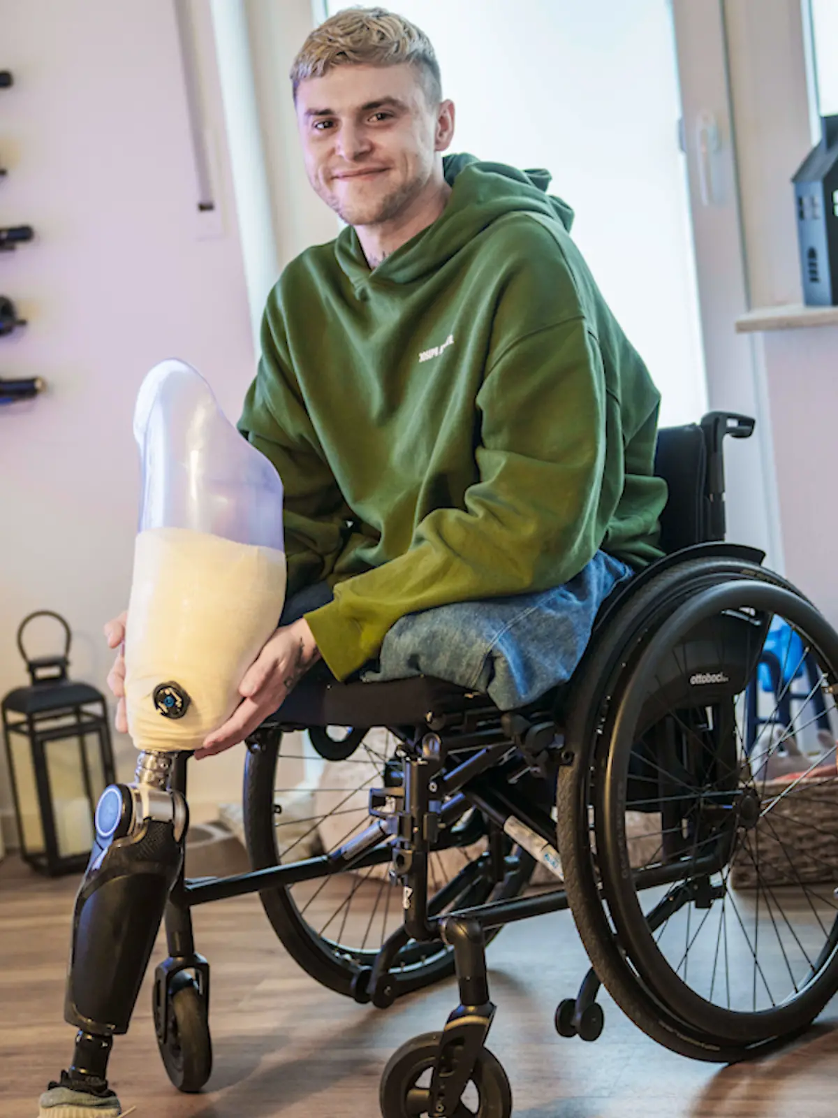 Alexander Sauer zeigt seine beiden Hightech-Prothesen in seinem Wohnzimmer.