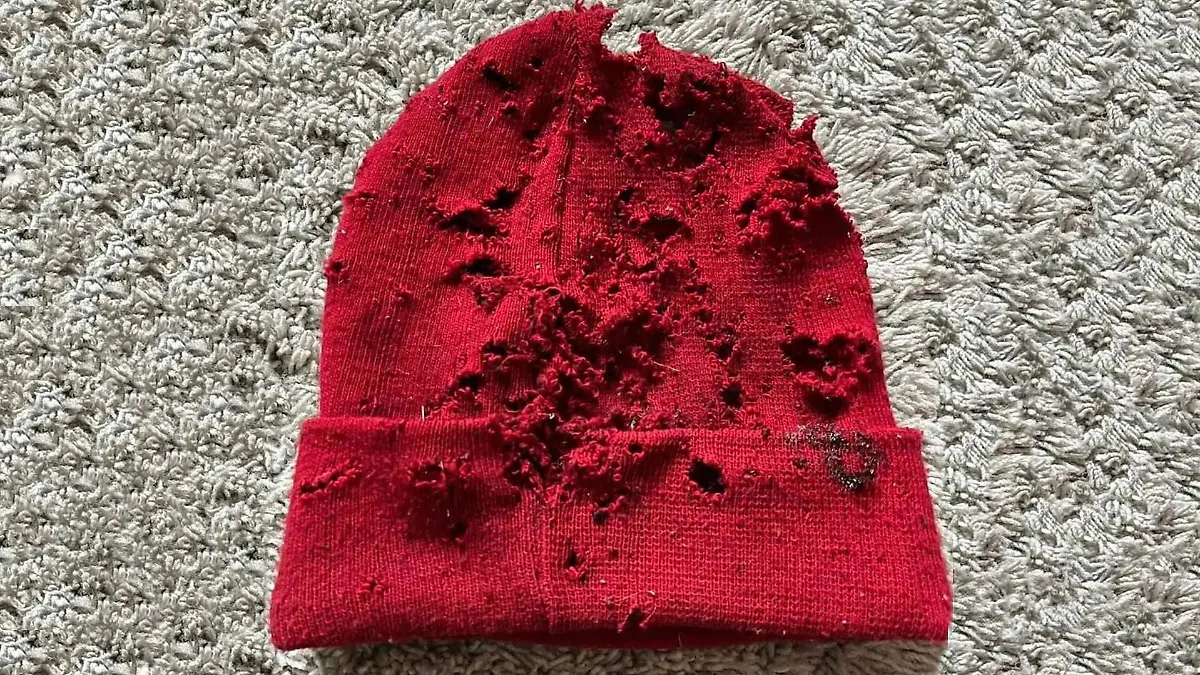 Rote Mütze, die von Schüssen durchlöchert ist