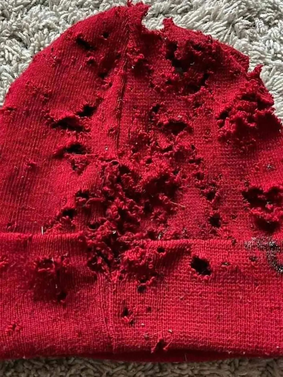 Rote Mütze, die von Schüssen durchlöchert ist