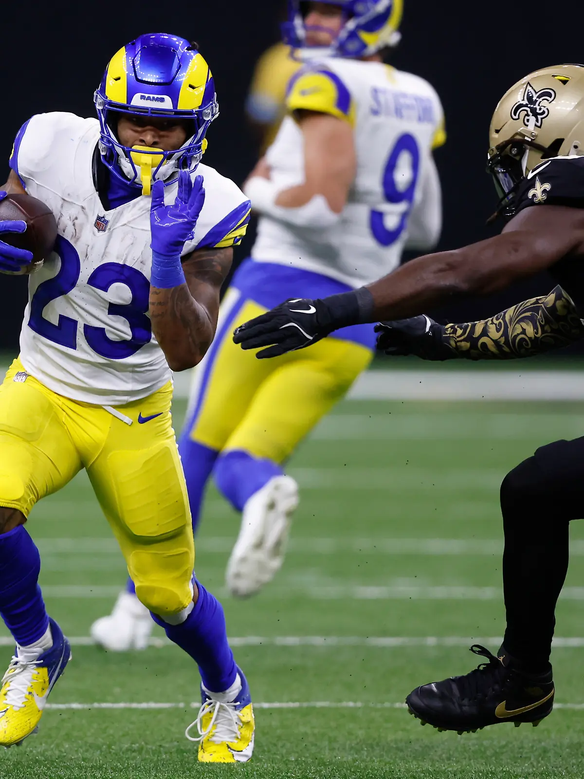 Los Angeles Rams Running Back Kyren Williams (23) läuft im NFL-Footballspiel gegen die New Orleans Saints mit dem Ball und wird von der rechten Seite attackiert.