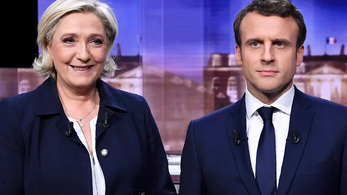 ARCHIV - 03.05.2017, Frankreich, La Plaine-Saint-Denis: Marine Le Pen, Präsidentschaftskandidatin der rechtsextremen Partei Rassemblement National (RN), und Emmanuel Macron, heutiger Präsident von Frankreich und damaliger Präsidentschaftskandidat der Bewegung «En Marche!», stehen vor dem Beginn einer live übertragenen Fernsehdebatte am 3. Mai 2017 zusammen. Vier Tage vor der Endrunde der französischen Präsidentschaftswahl treffen Staatschef Macron sowie seine Herausforderin Le Pen in einem mit Spannung erwarteten Fernsehduell aufeinander. Die traditionelle und einzige TV-Debatte wird am Mittwochabend (20.04.2022) ab 21.00 Uhr auf mehreren französischen Sendern übertragen. Foto: Eric Feferberg/AFP POOL/AP/dpa +++ dpa-Bildfunk +++