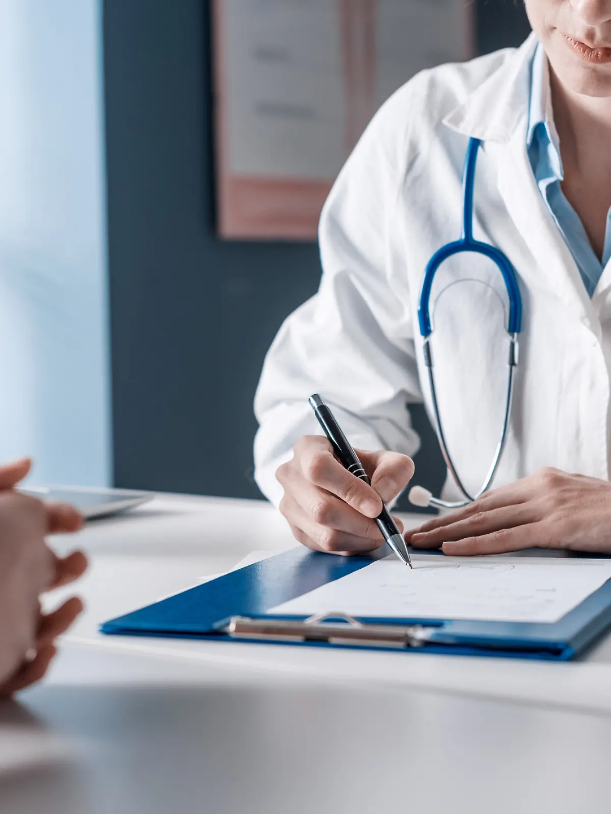 Frau sitzt bei Ärztin.