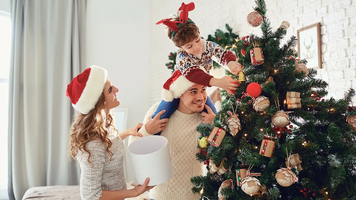 Eine Familie schmückt den Weihnachtsbaum.