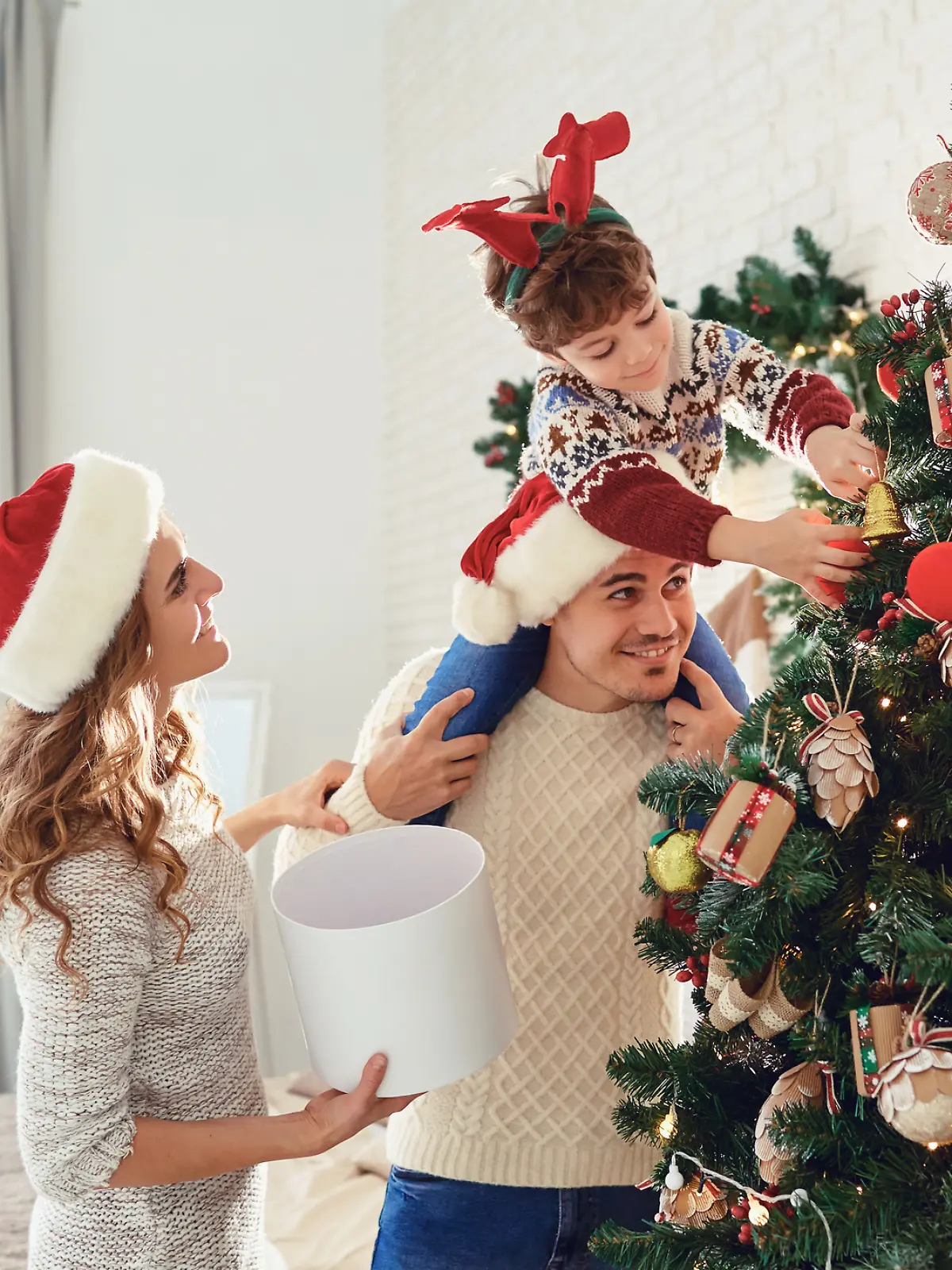 Eine Familie schmückt den Weihnachtsbaum.