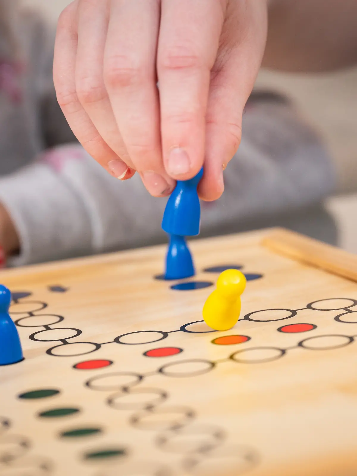 Ein junge spielt mit der Familie Mensch ärgere dich nicht.