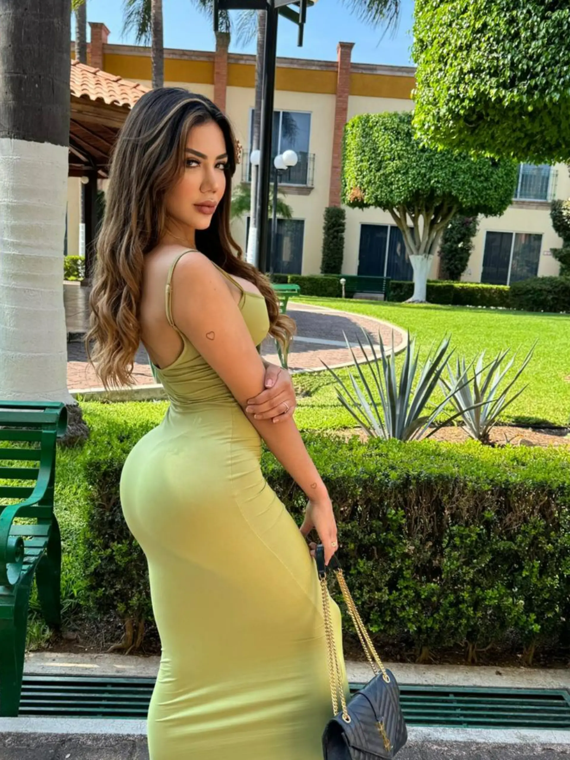 Fedra Oded Gaxiola Orozco in einem Garten vor Palmen. 