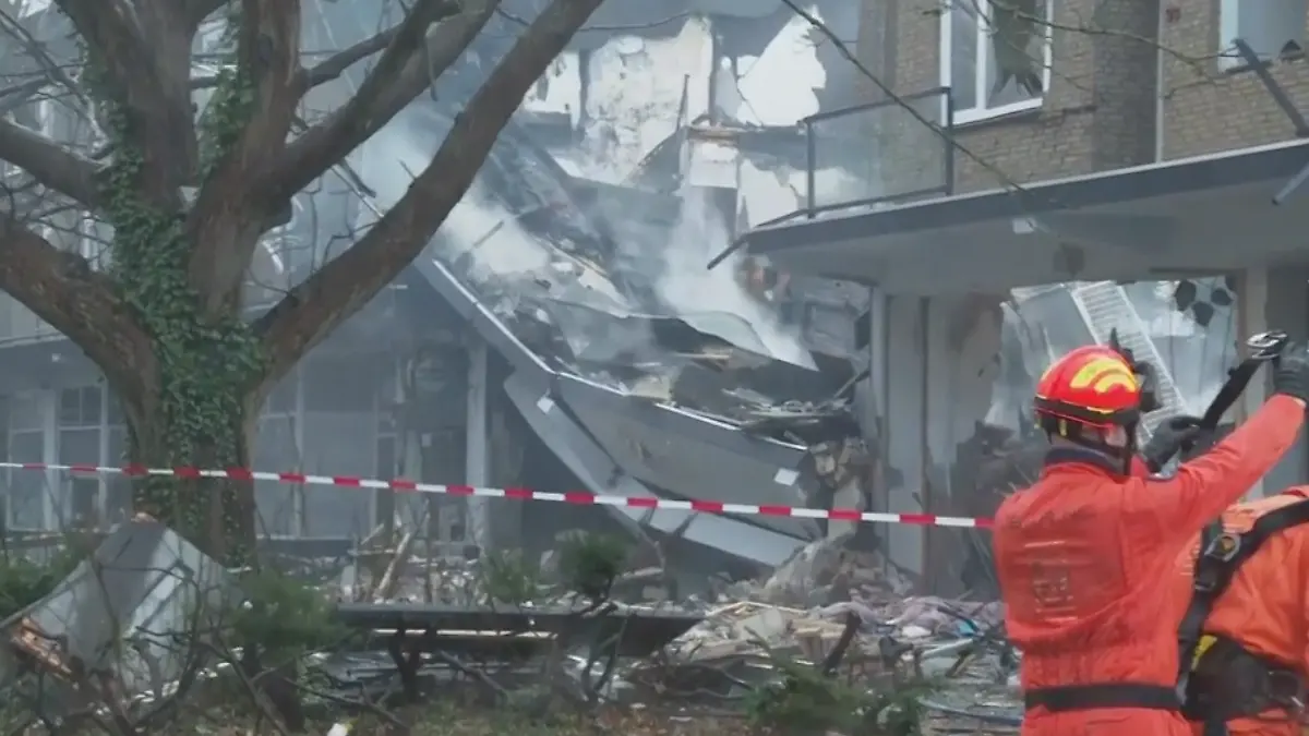Ein Rettungstrupp steht vor einem eingestürzten Gebäude.