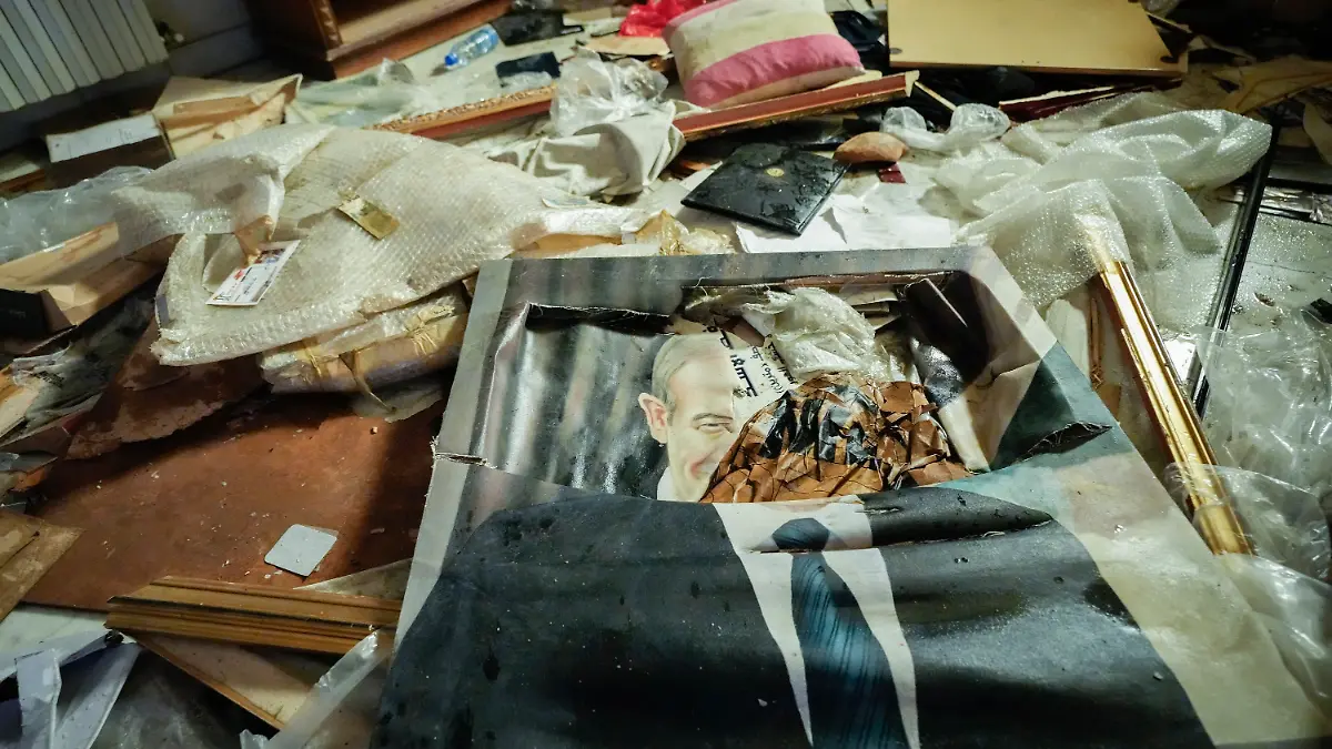08.12.2024, Syrien, Damaskus: Ein zerbrochenes Porträt des verstorbenen syrischen Präsidenten Hafis al-Assad liegt auf dem Boden, während Menschen in der durchwühlten Privatwohnung des syrischen Präsidenten Bashar Assad im Malkeh-Viertel nach Habseligkeiten suchen. Foto: Hussein Malla/AP/dpa +++ dpa-Bildfunk +++